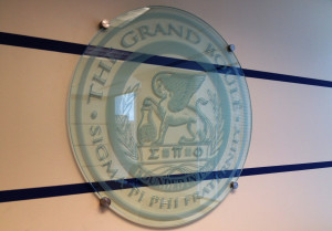 Fraternity seal sandblasted sign on stand-off mounting by Glass Graphics of Atlanta.